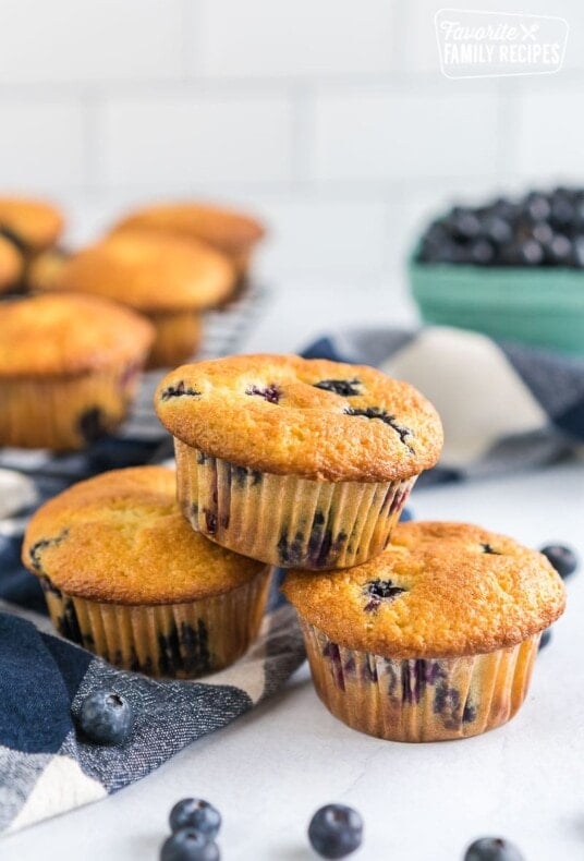 Three blueberry muffins stacked up on a table