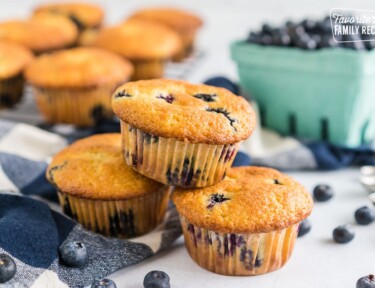 Three blueberry muffins stacked up on a table