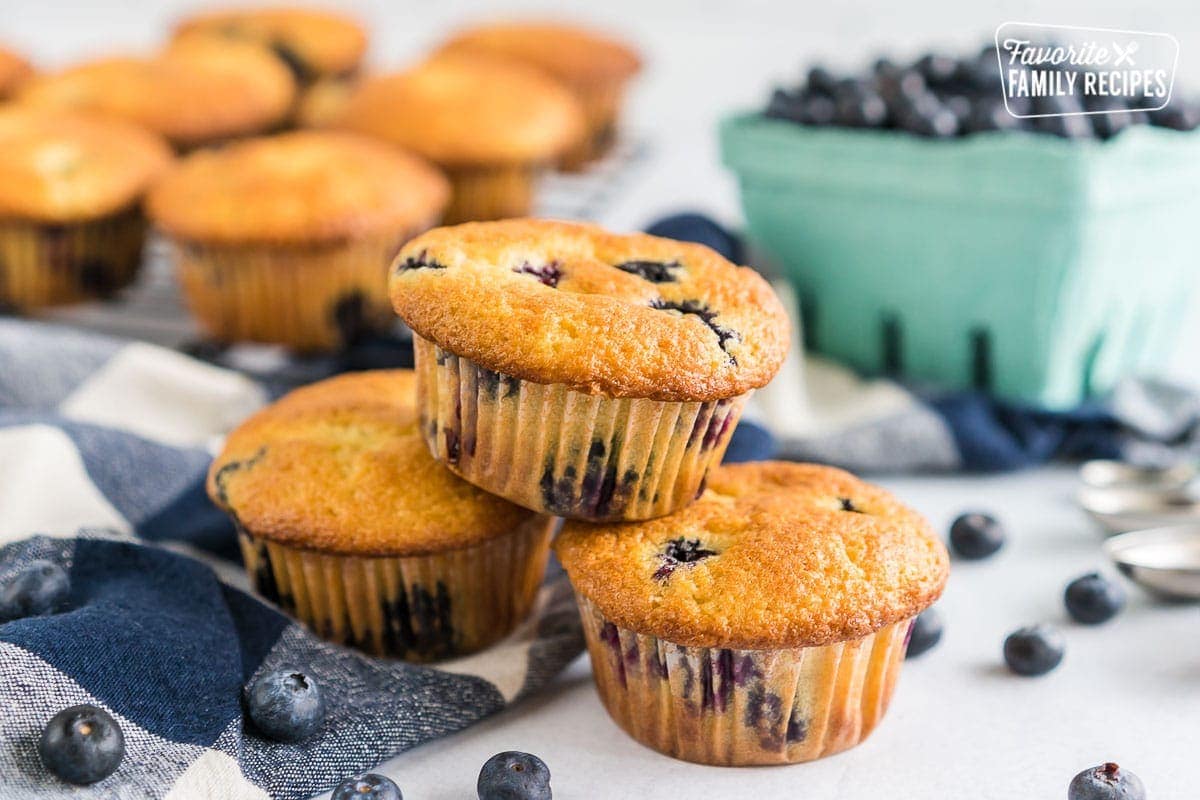 Three blueberry muffins stacked up on a table.