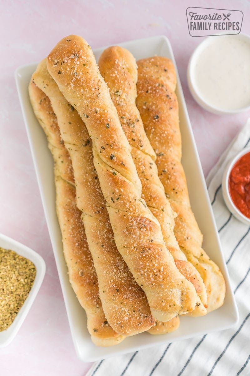 Breadsticks on a platter with dipping sauces