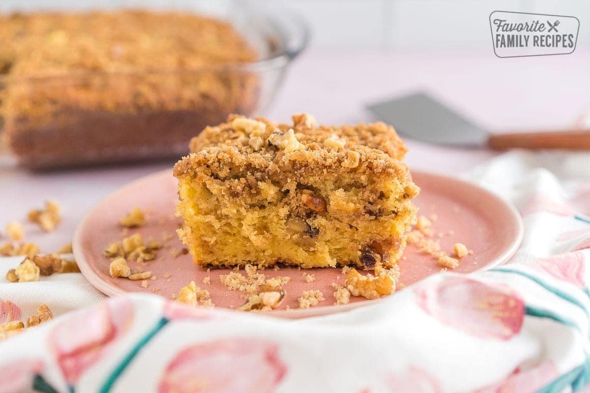 A piece of coffee cake on a pink plate.