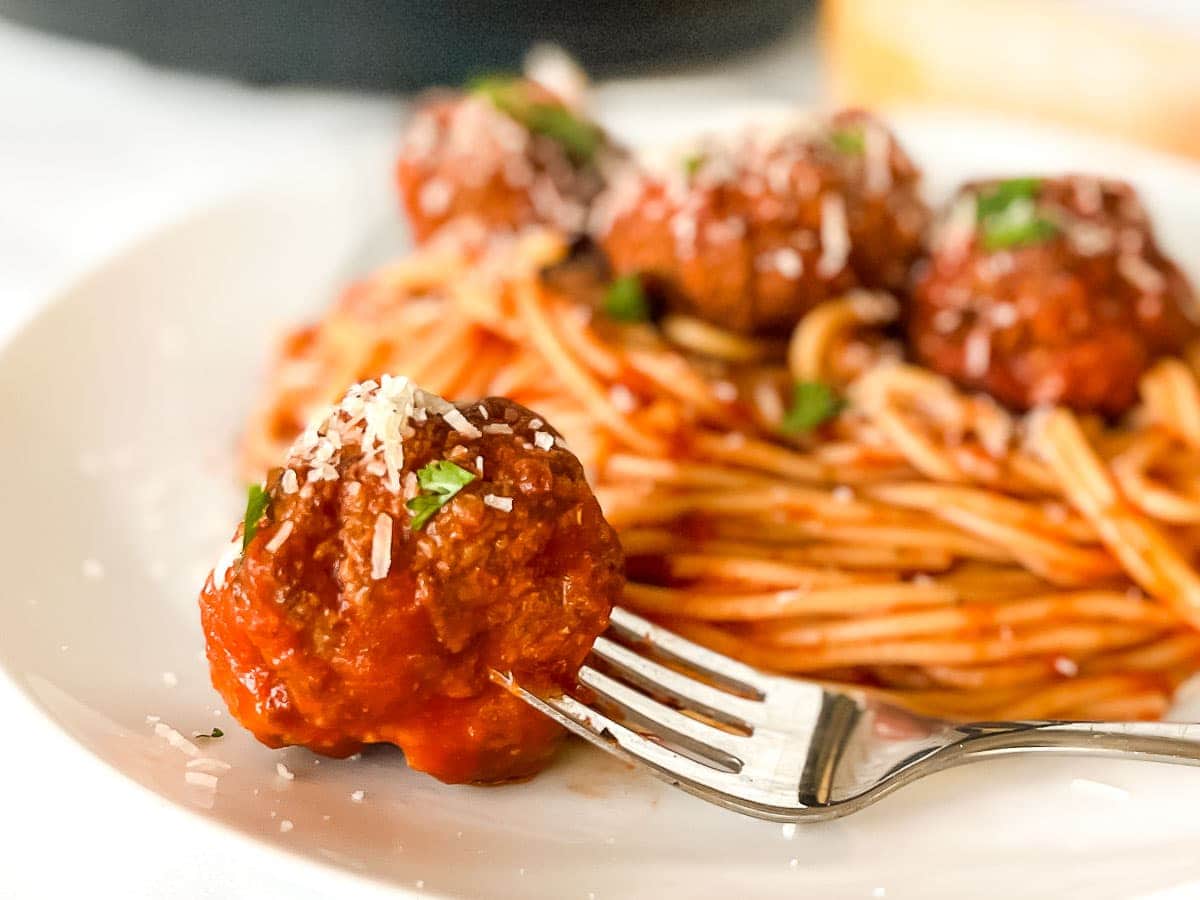 Close up of a meatball on a fork.