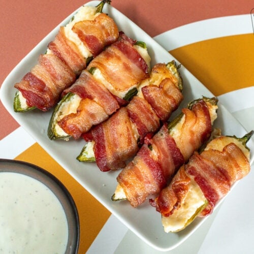 Bacon Wrapped Jalapeños poppers on a plate for serving.
