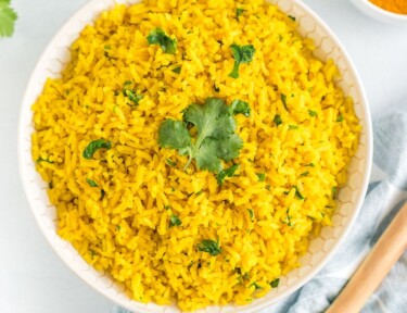 Yellow rice in a bowl topped with cilantro