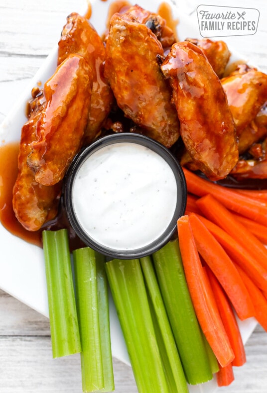 Overhead view of air fryer chicken wings on a plate with veggies and ranch dip