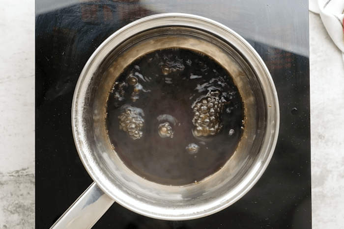 Balsamic vinegar and sugar simmering in a saucepan for Strawberry Bruschetta.