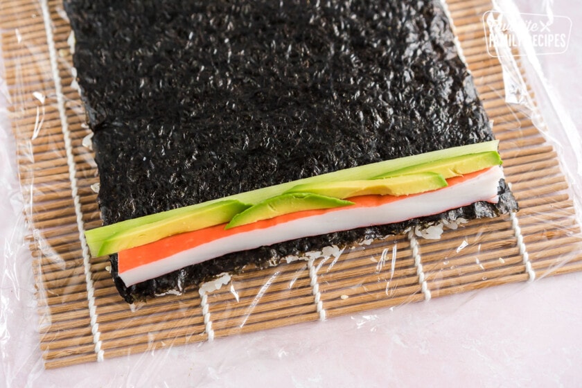 Crab, avocado, and cucumber on top of a sheet of nori and rice