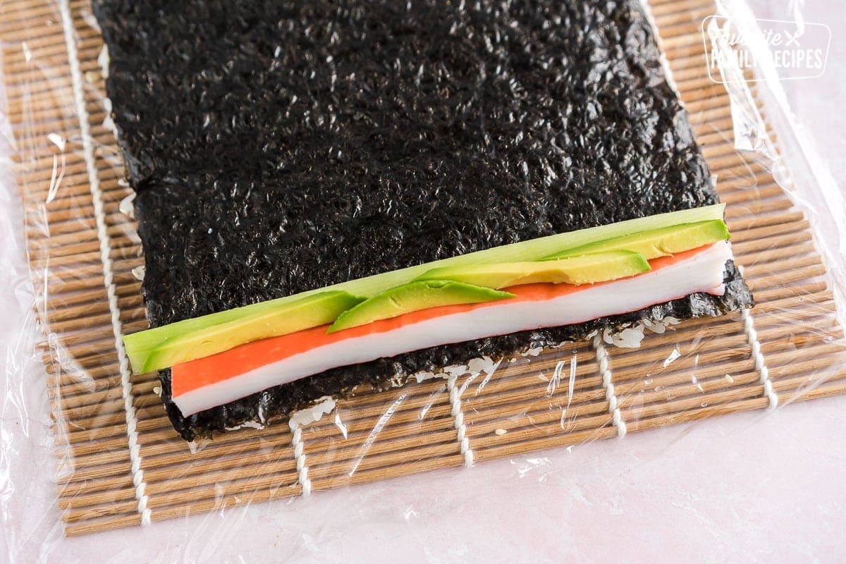 Crab, avocado, and cucumber on top of a sheet of nori and rice