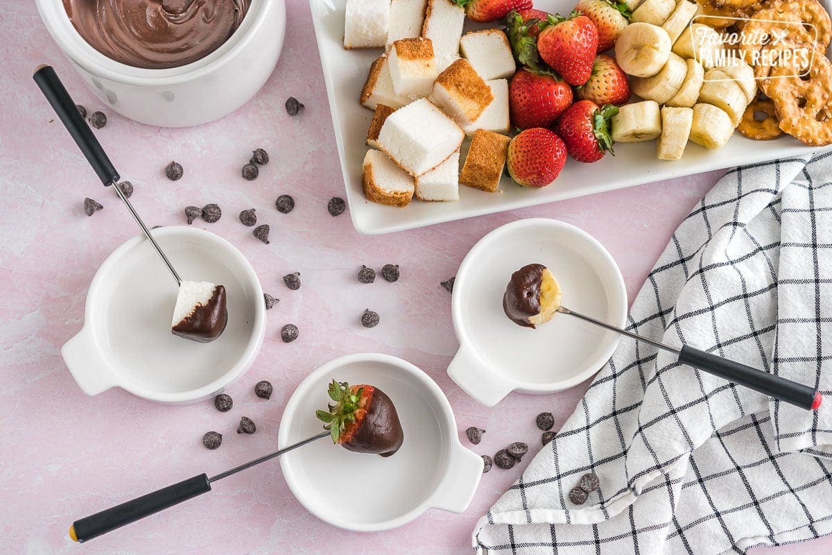 A tray of fondue dippers with chocolate fondue on the side