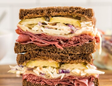 A corned beef sandwich cut in half and stacked one half on top of the other