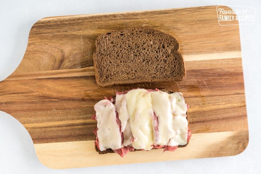An open faced sandwich on a cutting board.