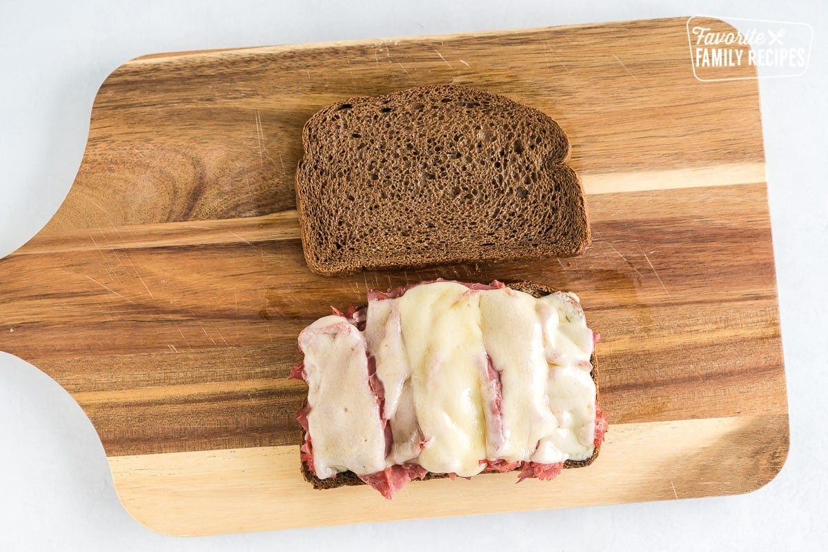 An open faced sandwich on a cutting board