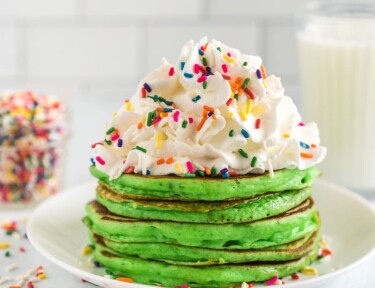Stack of Green Pancakes for St. Patrick's Day with whip cream and rainbow sprinkles