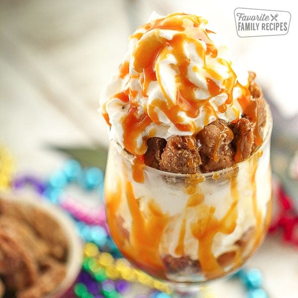 A pecan praline sundae in a clear dish topped with caramel topping