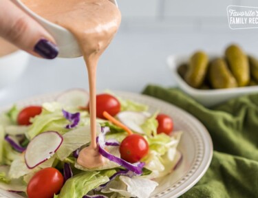 Russian Dressing being poured on a salad