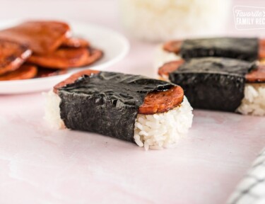 Close up side view of Spam Musubi with spam on a bed of rice wrapped in seaweed