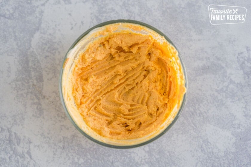 A bowl of yolk mixture with sriracha