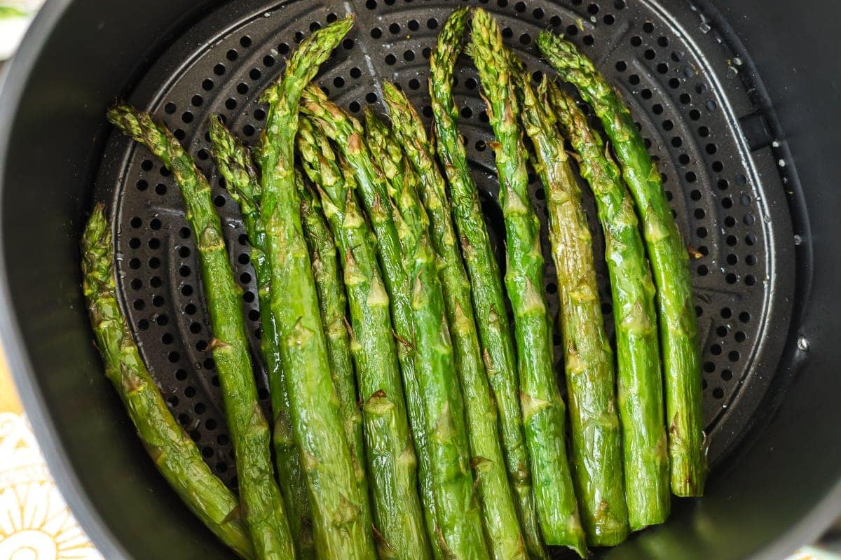 Cooked asparagus in an air fryer.