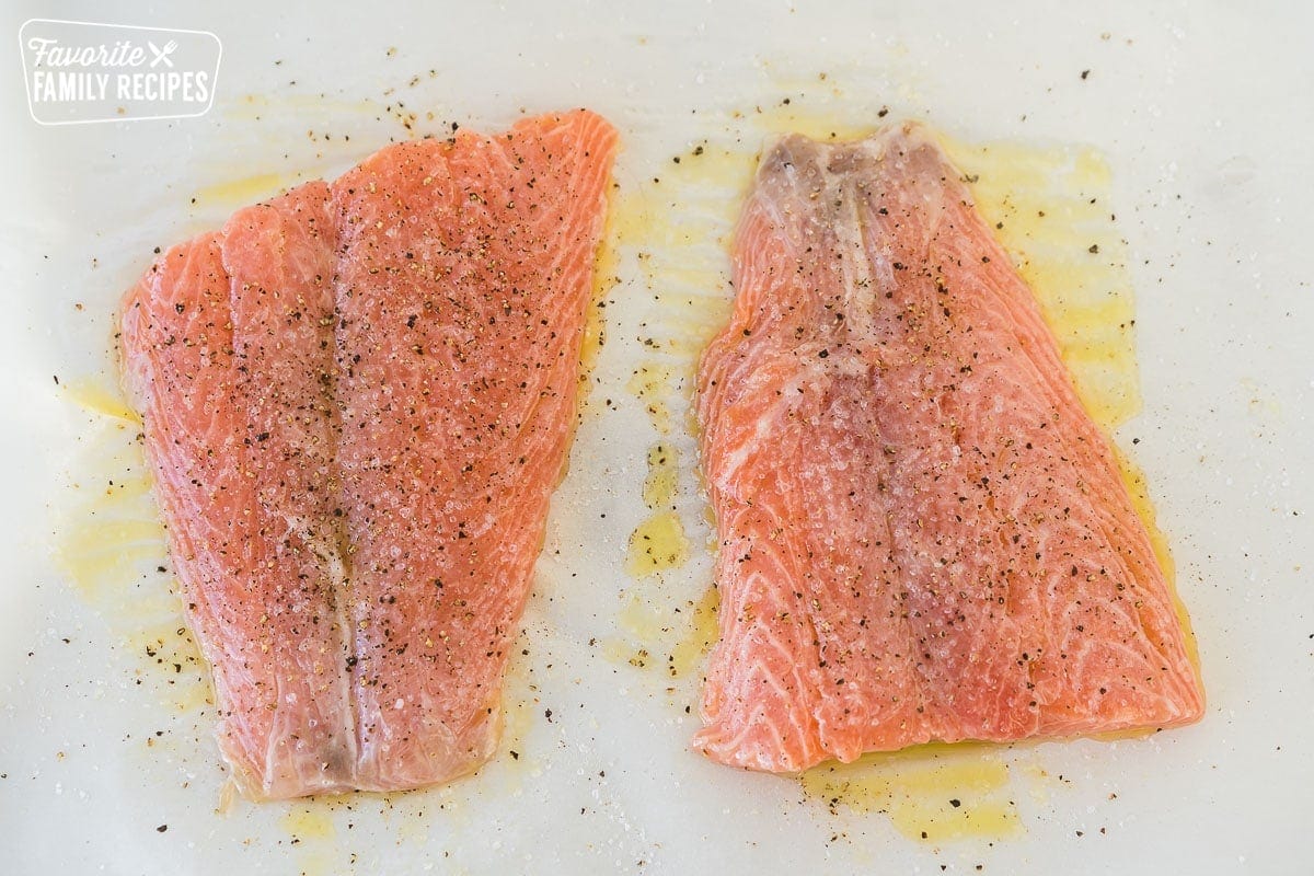 Two salmon filets covered with olive oil, lemon, salt and pepper
