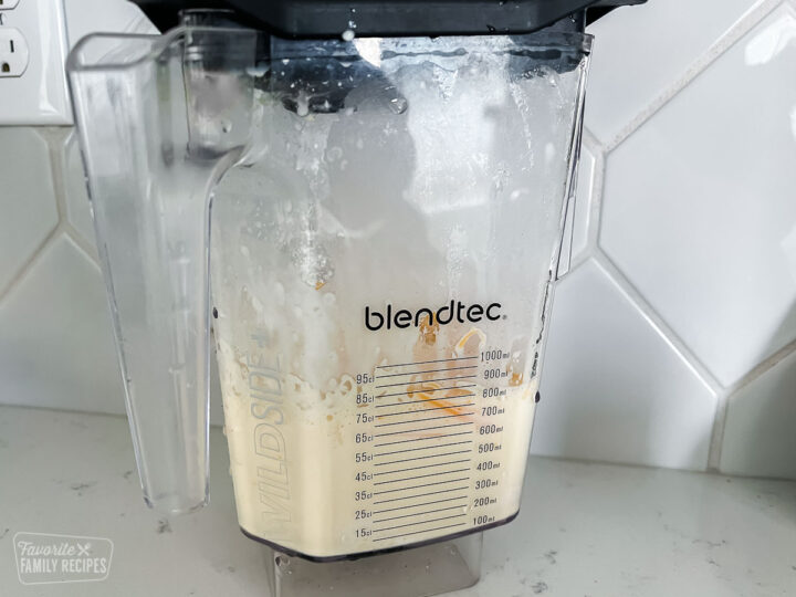 A blender with the ingredients to make Brazilian cheese bread blended together
