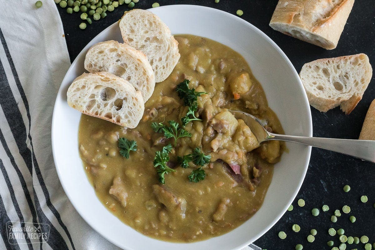 A bowl of split pea soup with a spoon