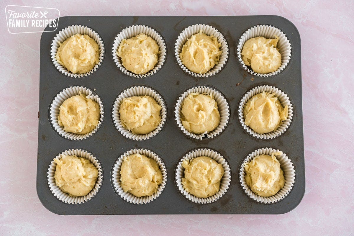 Coconut cupcake batter scooped into cupcake liners in a muffin tin