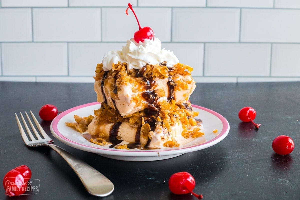 Fried ice cream with a crunchy corn flake topping surrounded by cherries.