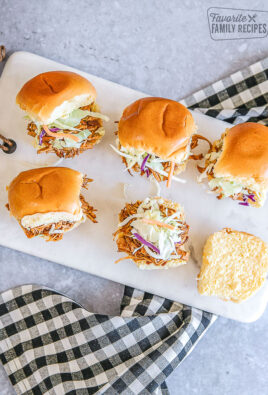 Pulled pork sliders on a marble tray with a black and white checkered napkin underneath