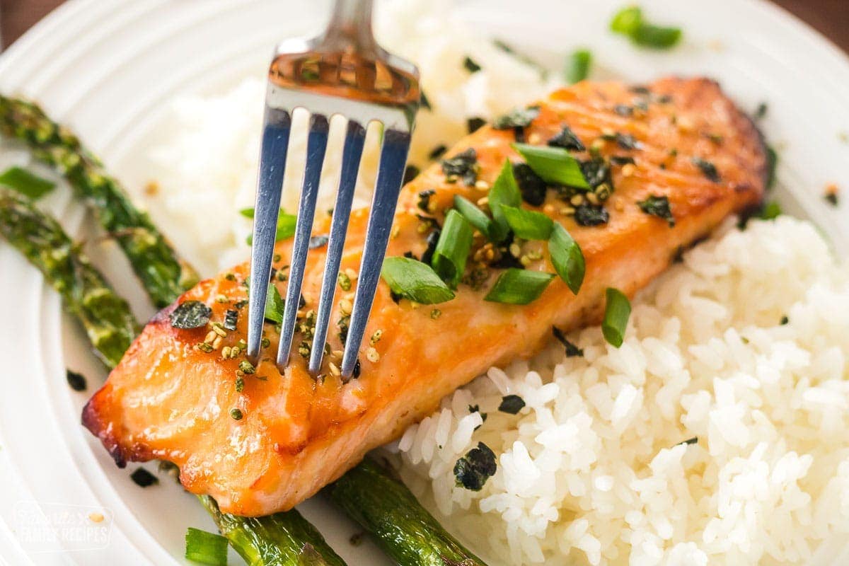 A close up of miso salmon with a fork in it