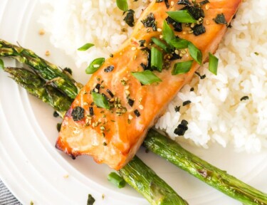 A top view of miso salmon on a plate with rice and asparagus