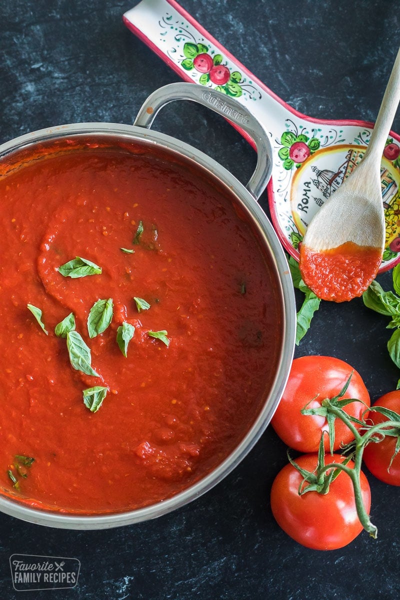 A pan with pomodoro sauce (Italian tomato sauce) next to tomatoes