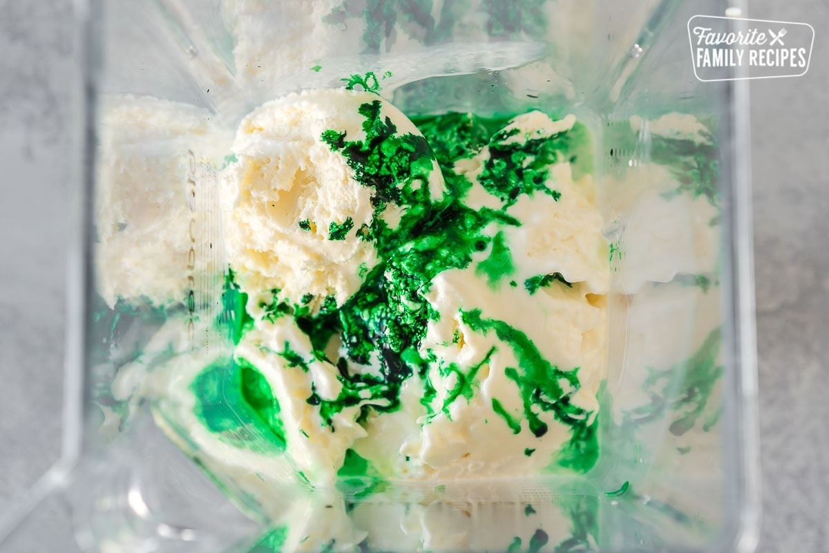 Ice cream, milk, mint extract, and green food coloring in a blender