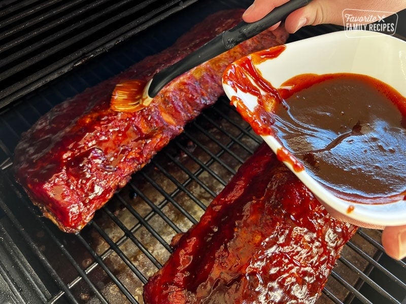 Ribs in the smoker getting basted with bbq sauce