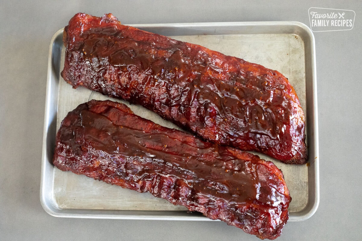 2 racks of smoked ribs on a baking sheet