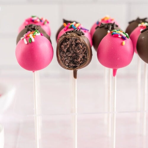 A chocolate cake pop with a bite taken out of it revealing the filling