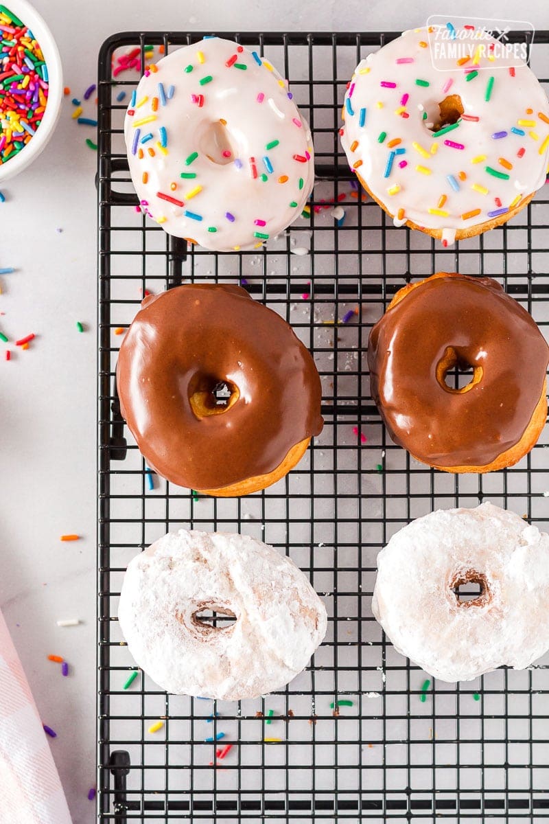 Six decorated cronuts decorated on a cooling rack.