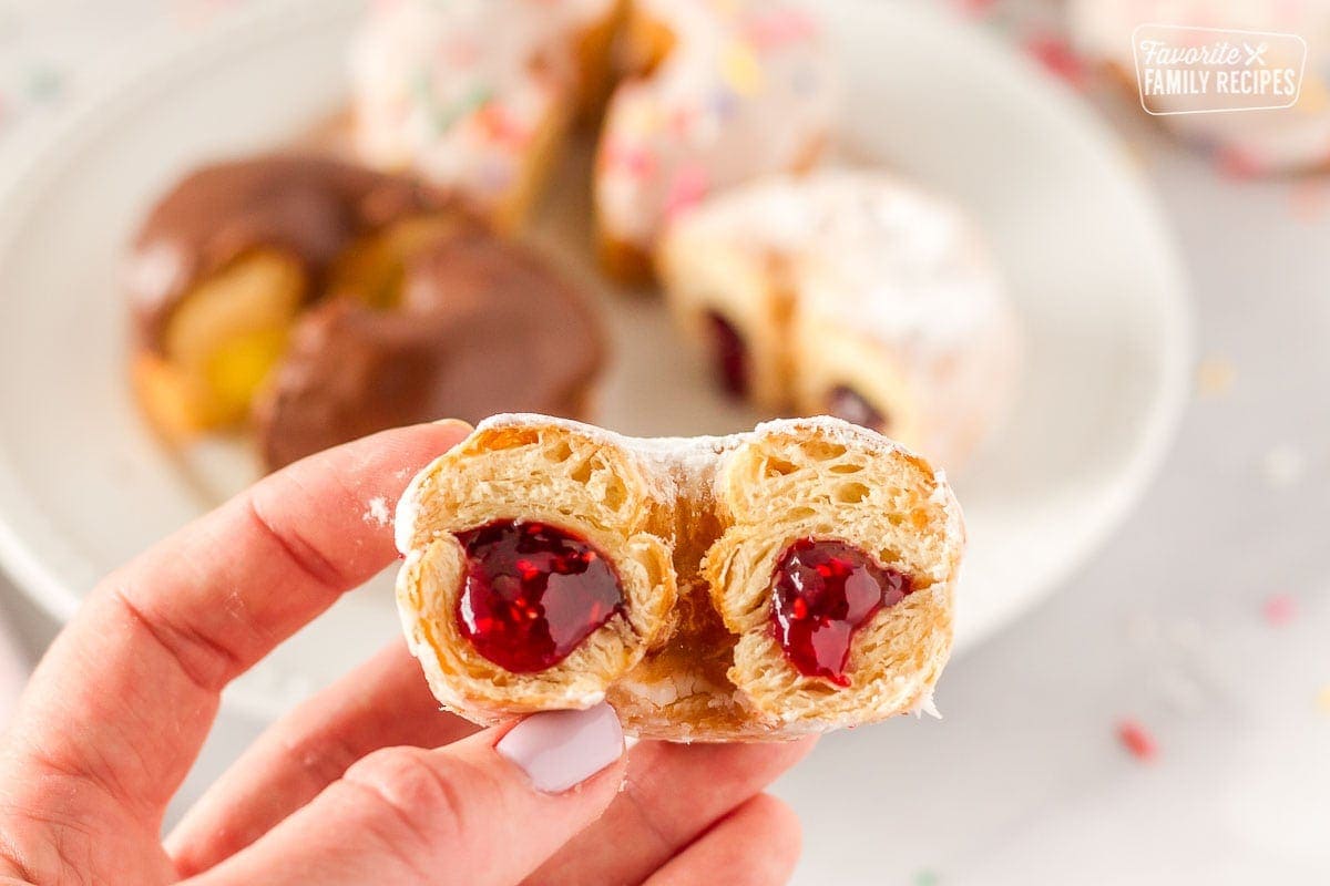 Close up of raspberry filled cronut cut in half to show filling