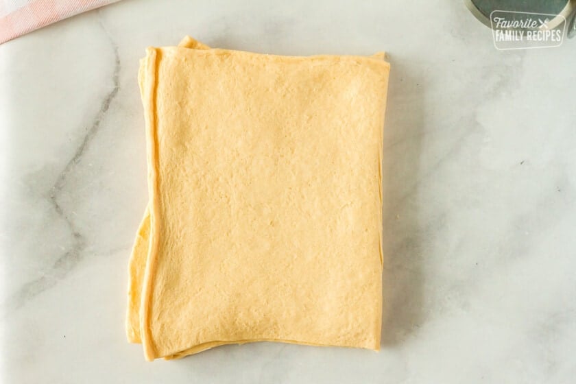 Stack of four crescent dough halves for cronuts.