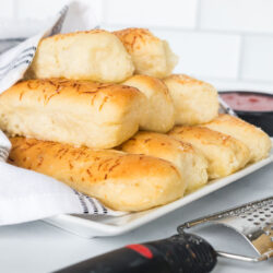 Soft and fluffy breadsticks bundled together and wrapped in a kitchen towel