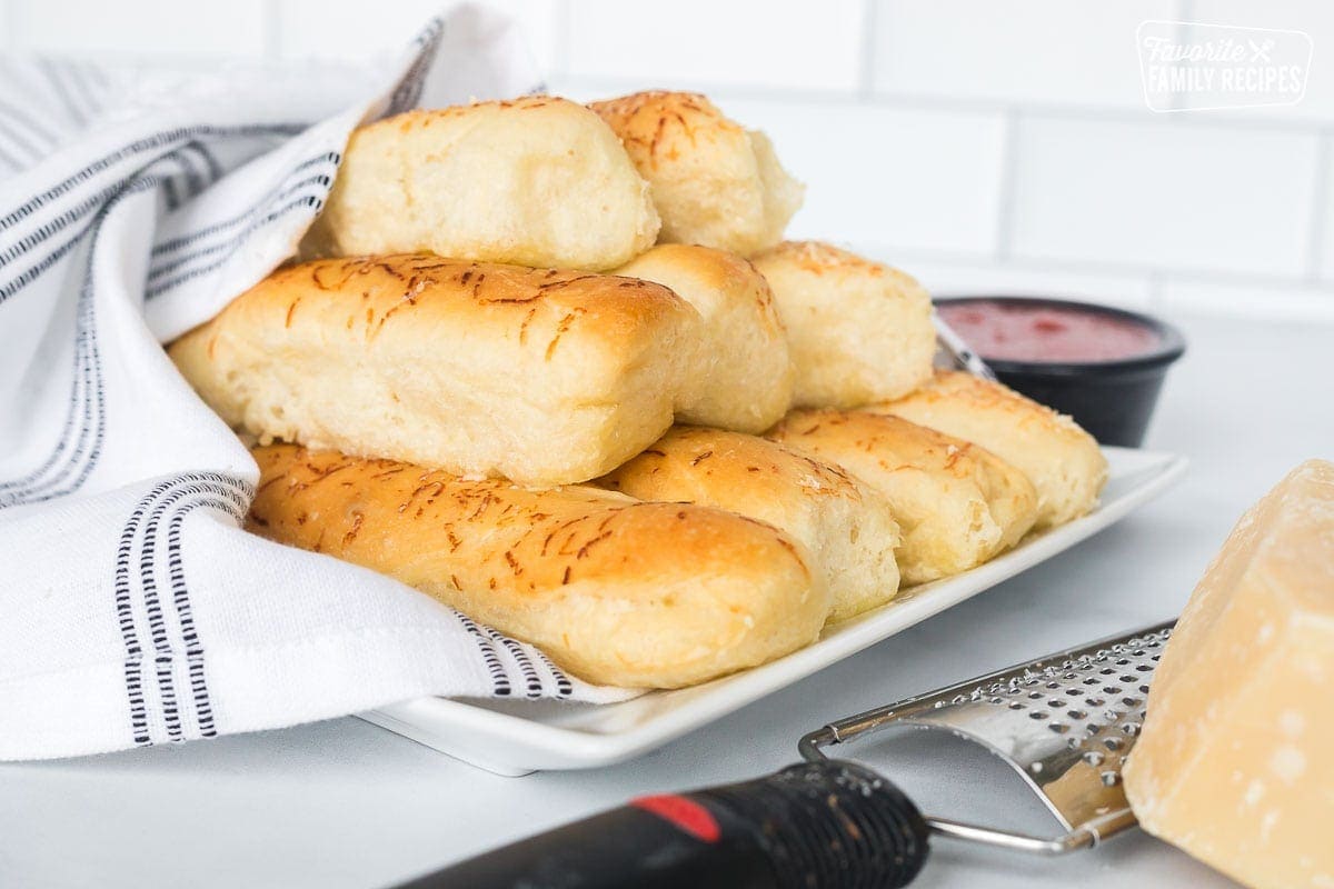 Soft and fluffy breadsticks bundled together and wrapped in a kitchen towel.