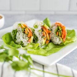 Three fresh spring rolls cut in half on a bed of lettuce