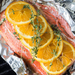 Grilled salmon in a foil packet with oranges and thyme on top