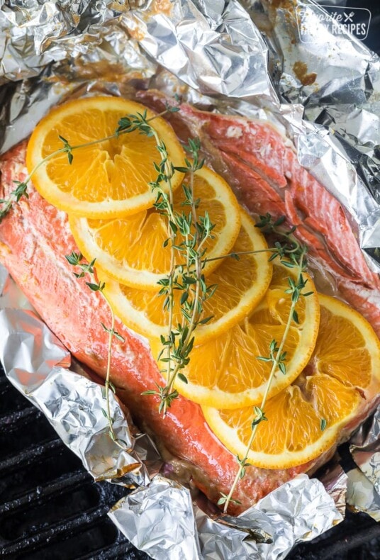 Grilled salmon in a foil packet with oranges and thyme on top