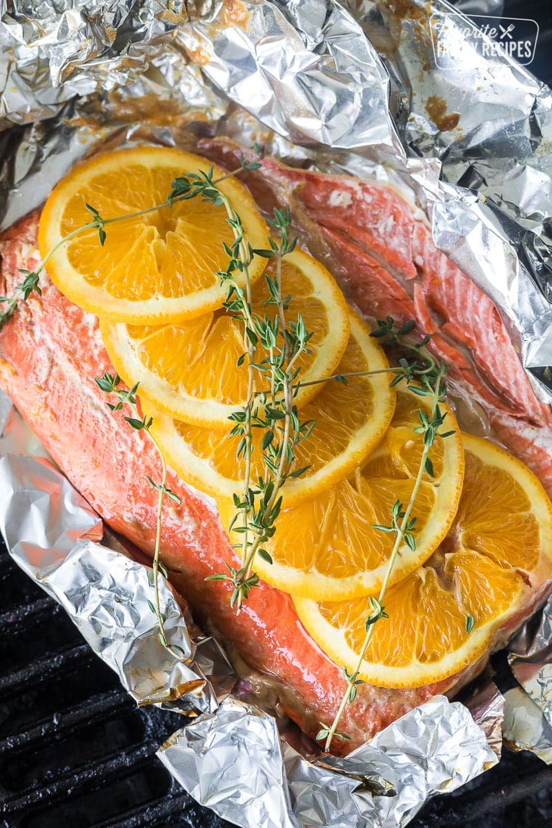 Grilled salmon in a foil packet with oranges and thyme on top