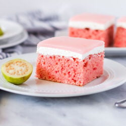 Slice of Hawaiian guava cake with a fresh sliced guava half on the side.