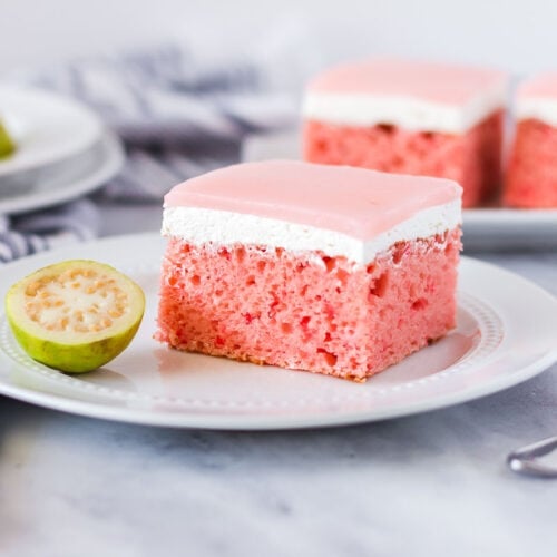 Slice of Hawaiian guava cake with a fresh sliced guava half on the side.