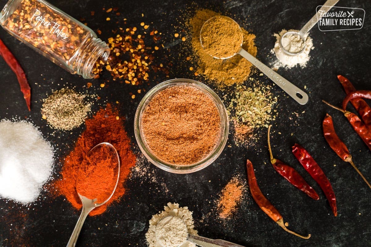 Homemade taco seasoning in a jar surrounded by all the ingredients to make taco seasoning