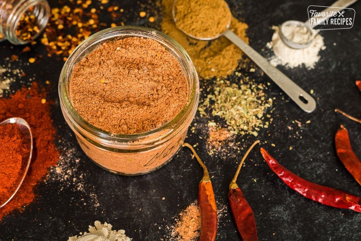 A jar of homemade taco seasoning on a black table top