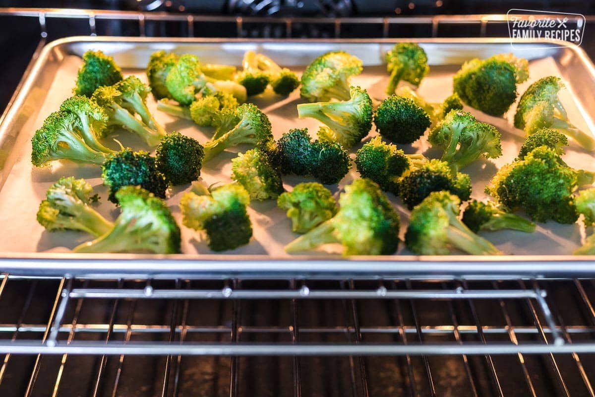 Broccoli on a large baking sheet roasting in the oven