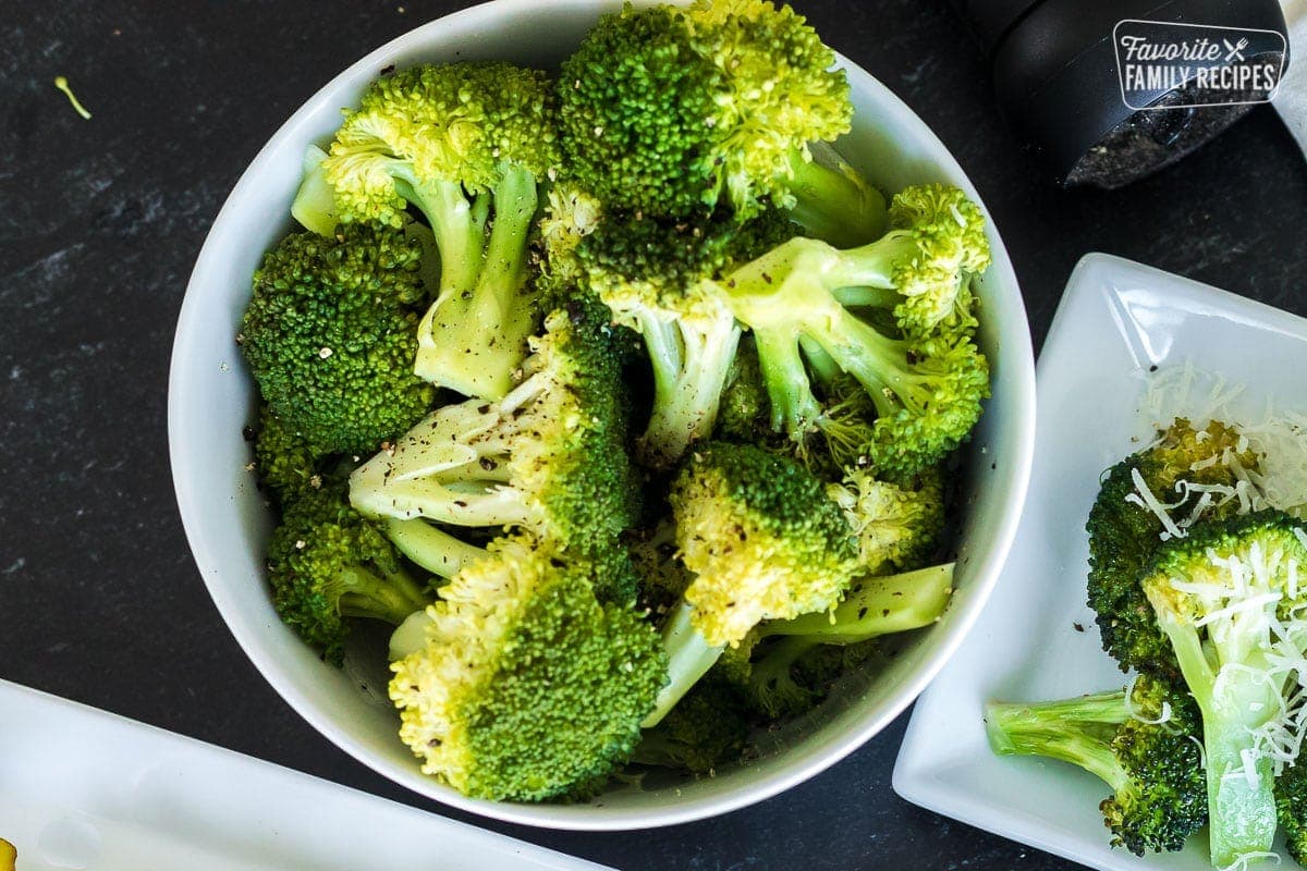 Steamed broccoli in a white bowl with salt and pepper
